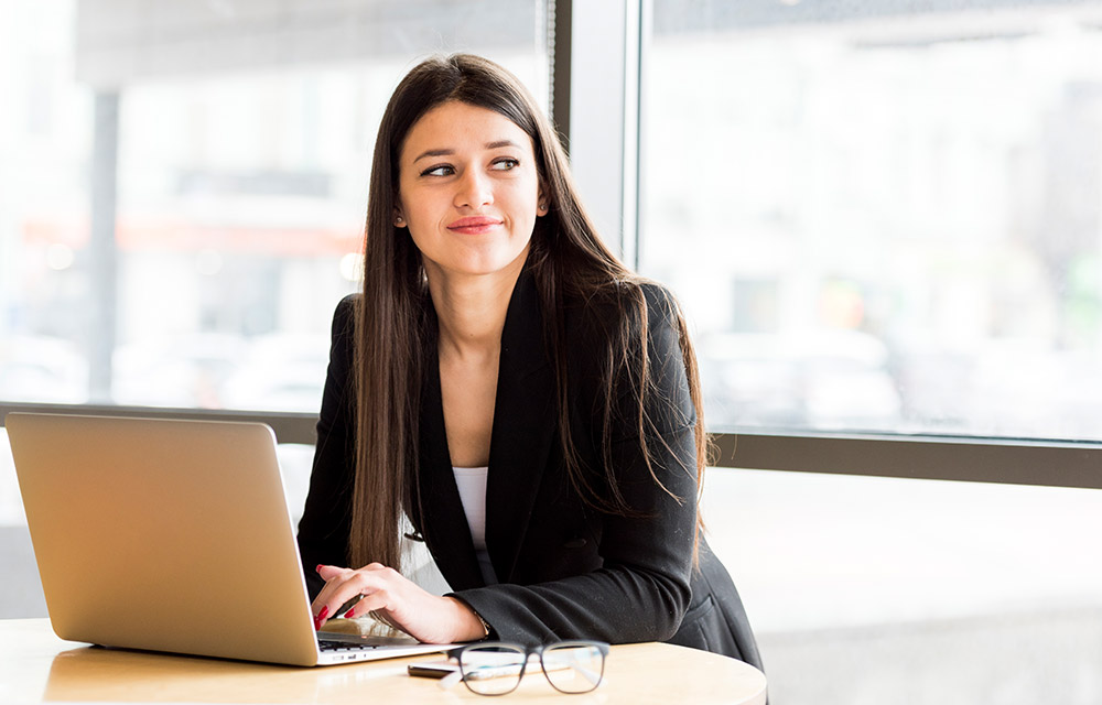 The image shows two girls sitting in front of their laptop sharing an envelope containing message The image shows two girls sitting in front of their laptop sharing an envelope containing message